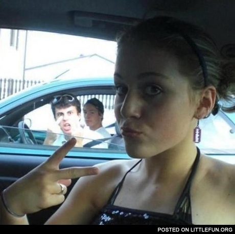 Photobomb. Guy in the car showing a middle finger.
