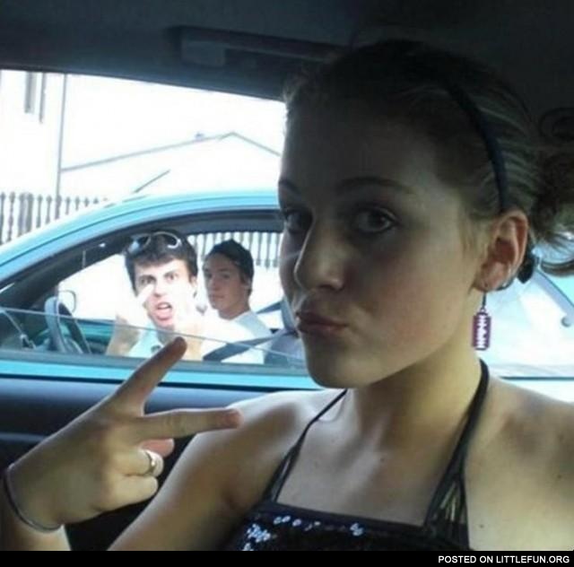 Photobomb. Guy in the car showing a middle finger.