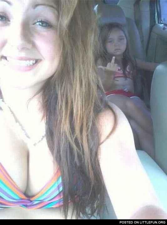Photobomb. Daughter in the car showing a middle finger.